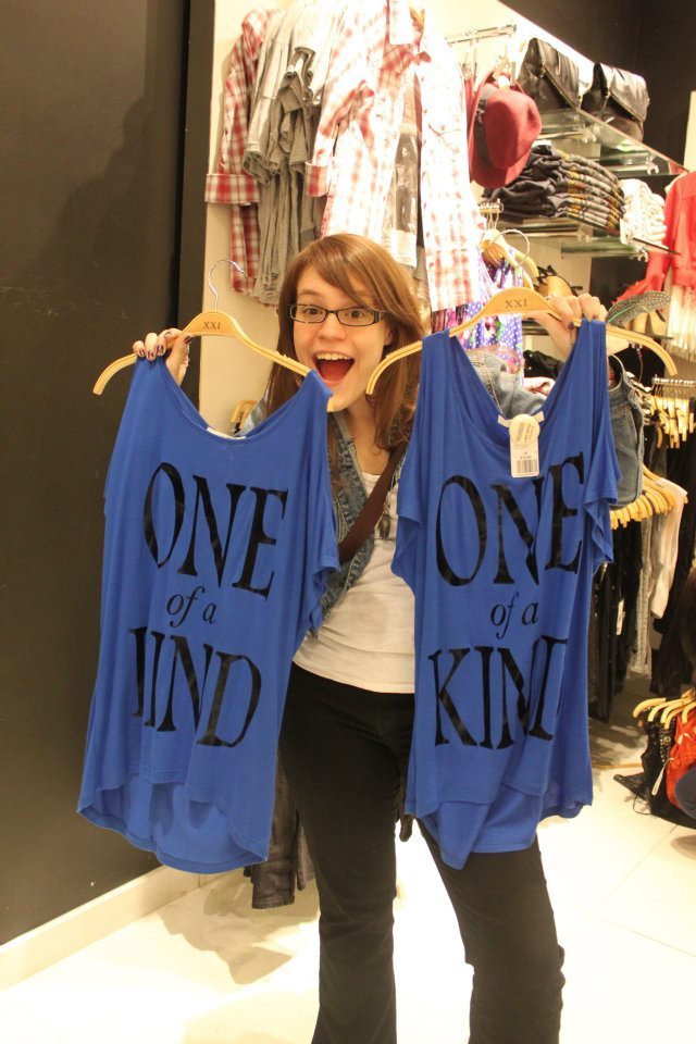 Photo of Shannon holding two identical shirts saying "One of a kind"